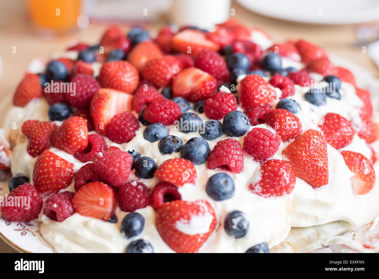 Pavlova cake with strawberry, blueberry, raspberry and whipped cream