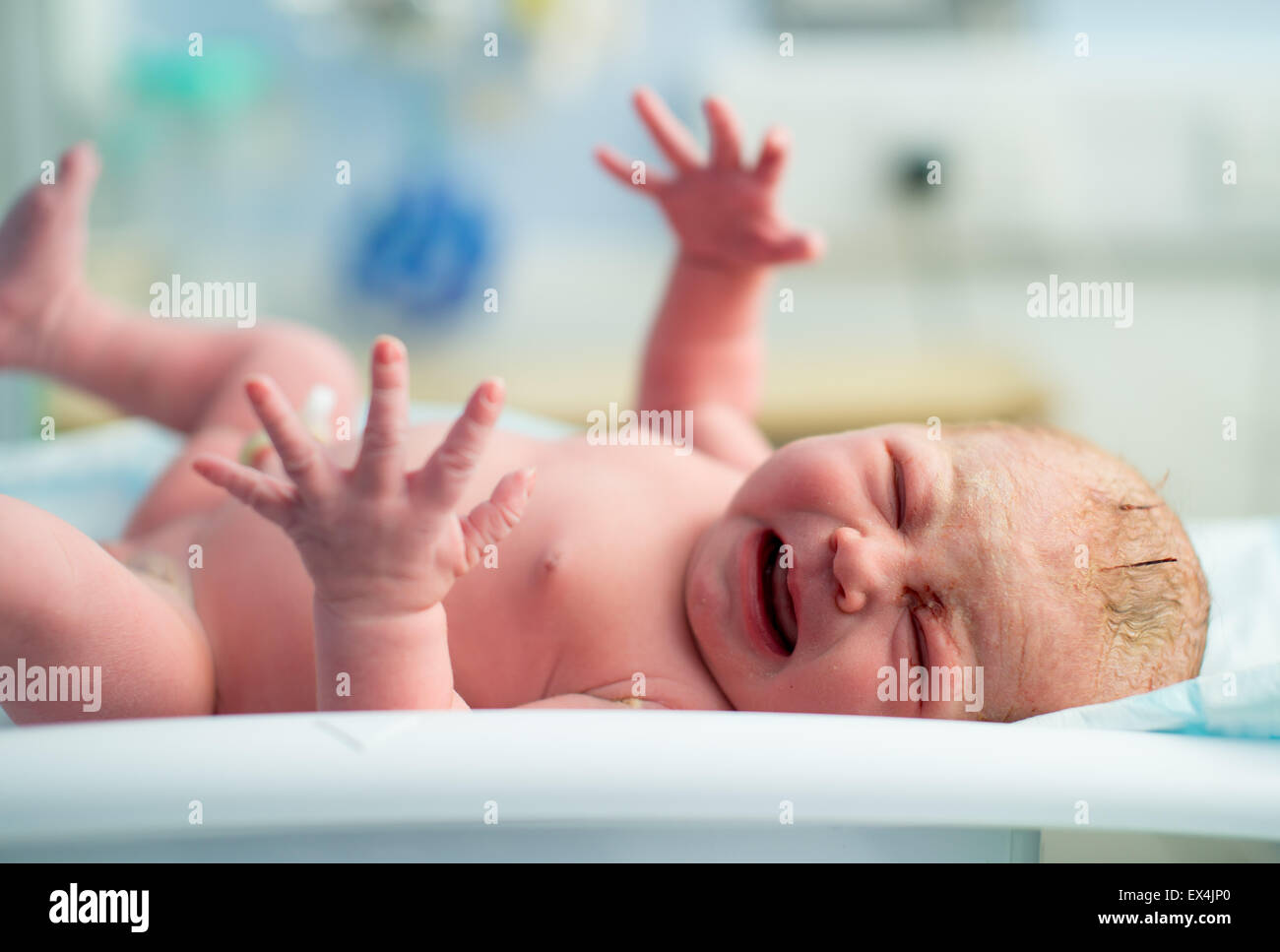 A newborn baby cries as it is weighed for the very first time Stock Photo
