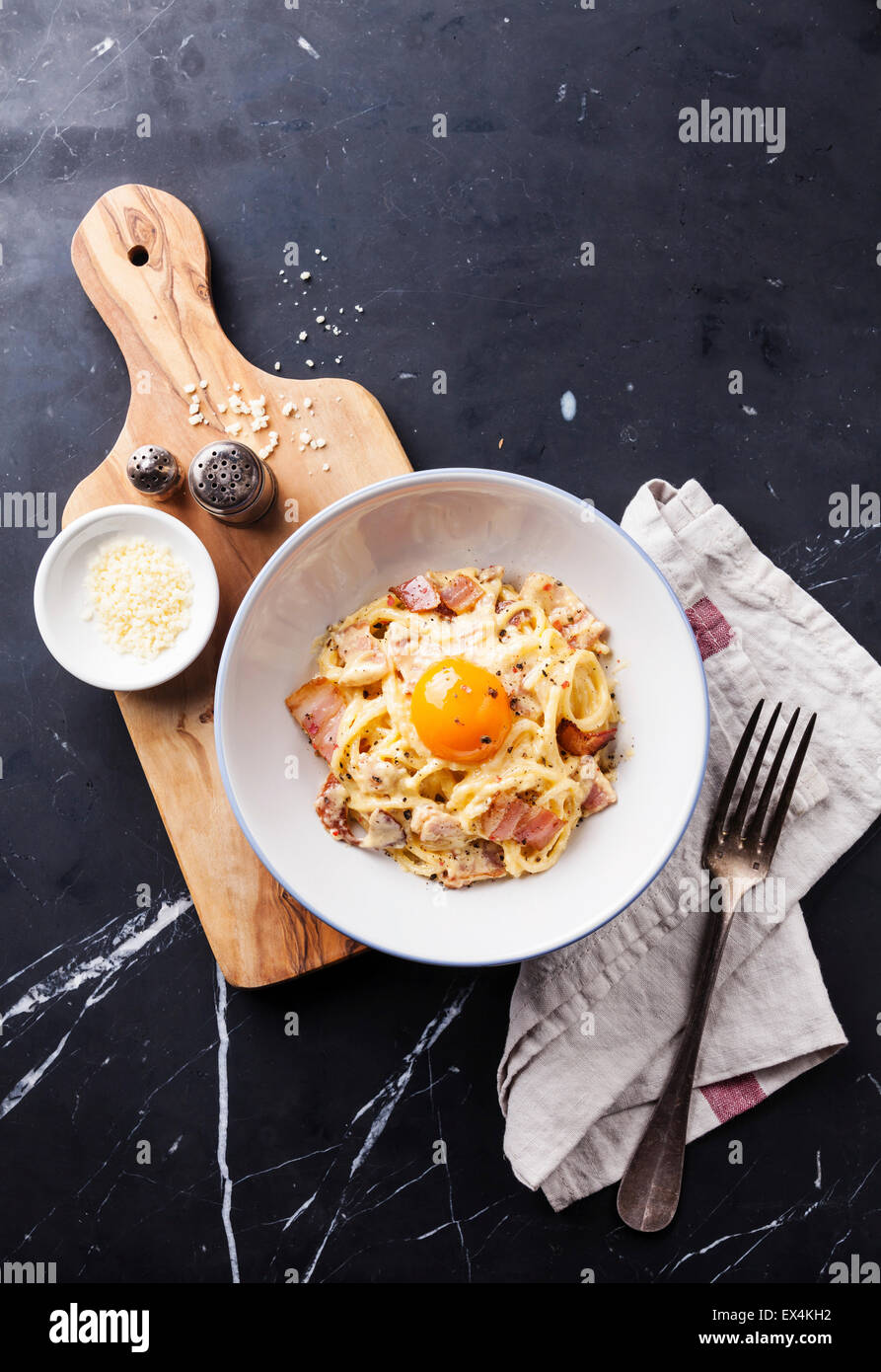 Pasta Carbonara with parmesan and yolk on dark marble background Stock Photo