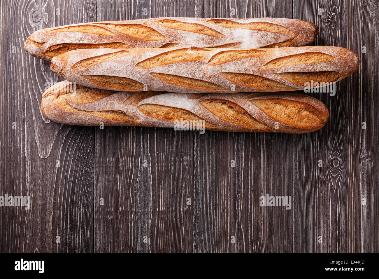 Three fresh French Baguette on gray wooden background Stock Photo