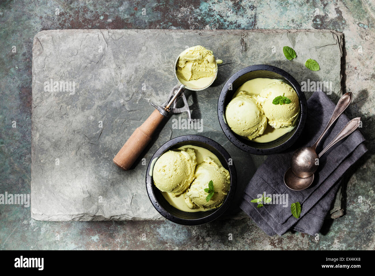 Green tea ice cream with mint leaves and Spoon for ice cream on stone slate background Stock Photo
