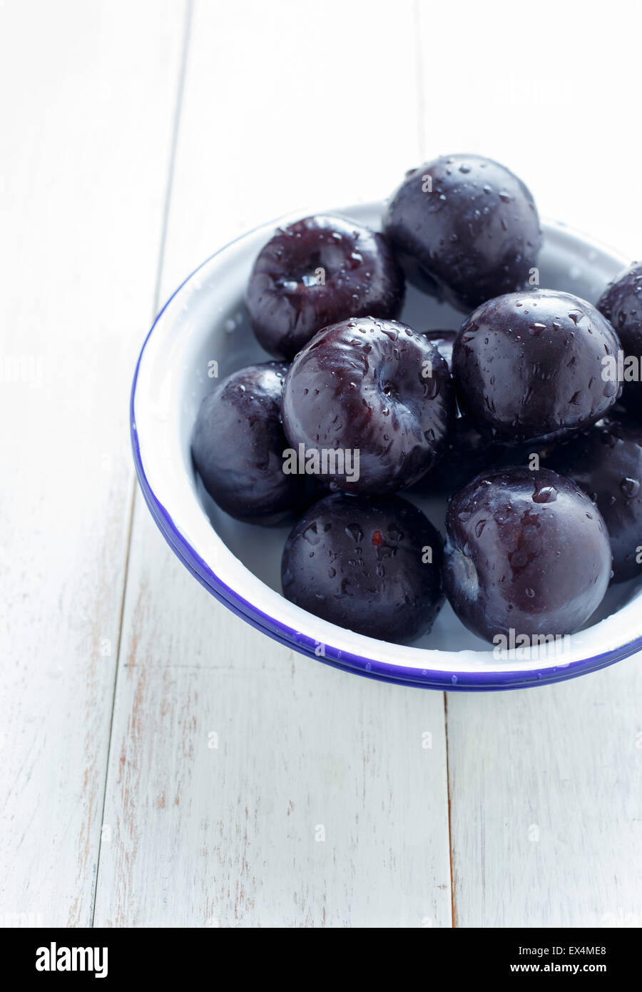 Plums - Whole in a Bowl,on a white rustic background Stock Photo