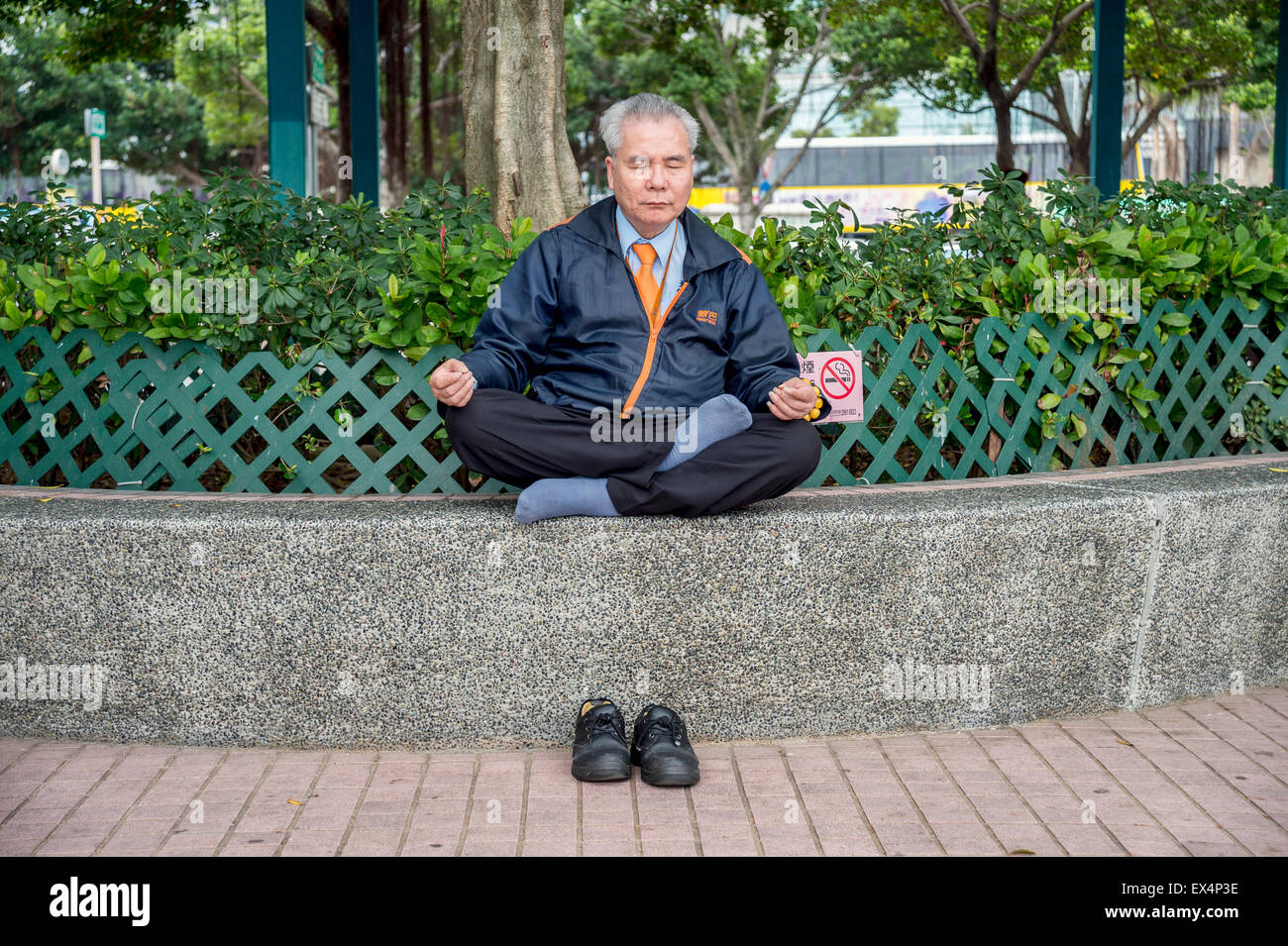 Chinese elderly man meditating in Hong Kong, China Stock Photo