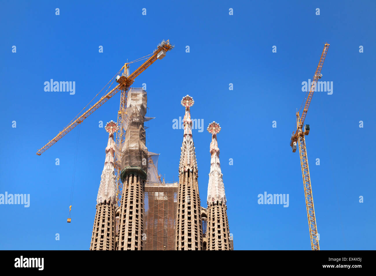 Tops of the towers or steeples, and cranes, Sagrada Familia cathedral designed by Gaudi, Barcelona Spain Europe Stock Photo