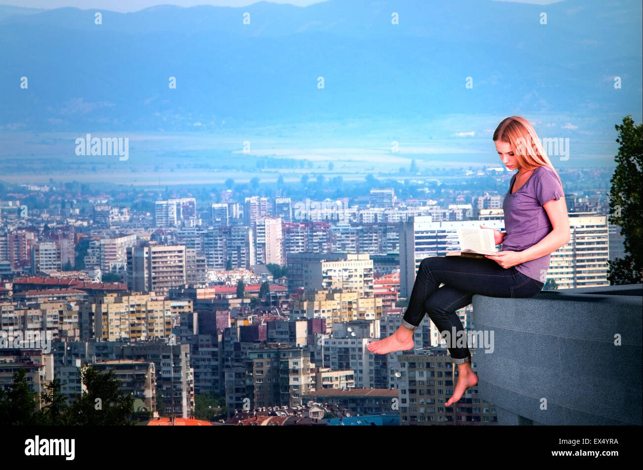 Woman sitting on roof and reading  book. Stock Photo