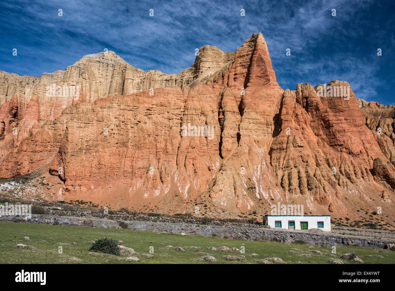 Red rock formations, Red Cliffs with house in front of erosion landscape, Dhakmar, former Kingdom of Mustang, Nepal Stock Photo