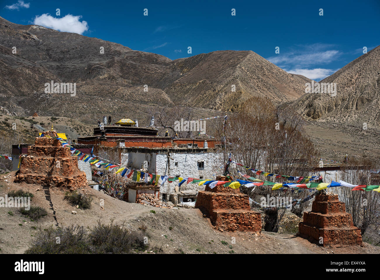 Ghar Gompa of Lo Gekar with prayer flags in front of mountain landscape, probably the oldest Buddhist monastery in Nepal Stock Photo