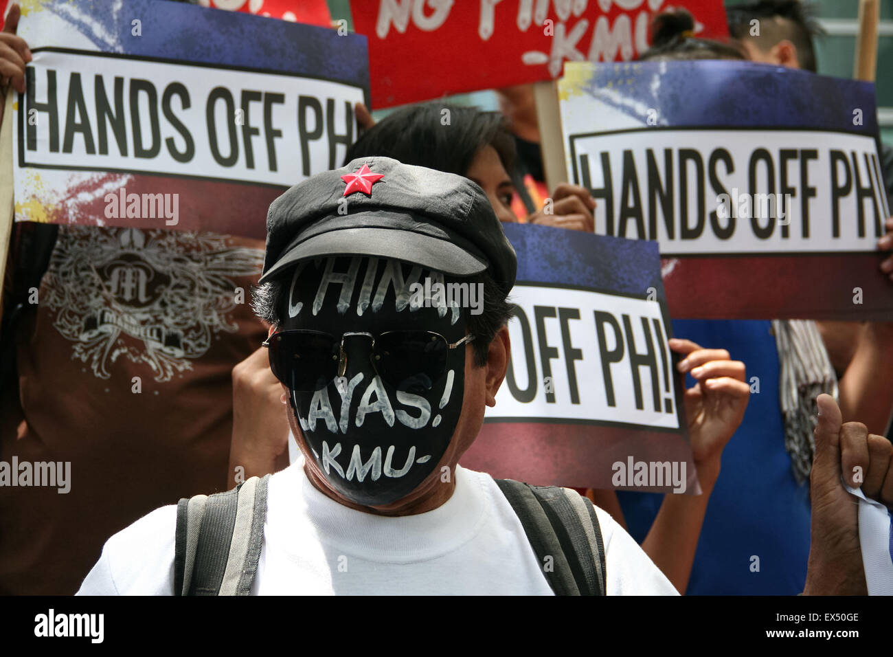 Makati, Philippines. 07th July, 2015. Protesters hold posters in front of the Chinese embassy in Makati CIty. Labor group Kilusang Mayo Uno (KMU) lead a protest march to the Chinese embassy in Gil Puyat Avenue, Makati, coinciding with the first day of hearing in the Arbital Tribunal in the Permanent Court of Arbitration in the Netherlands regarding the disputed islands in the South China Sea. The group reiterated that China's 9-dash line, and the structures that China built around the disputed islands, has no bearing based on UNCLOS. Credit:  J Gerard Seguia/Pacifc Press/Alamy Live News Stock Photo