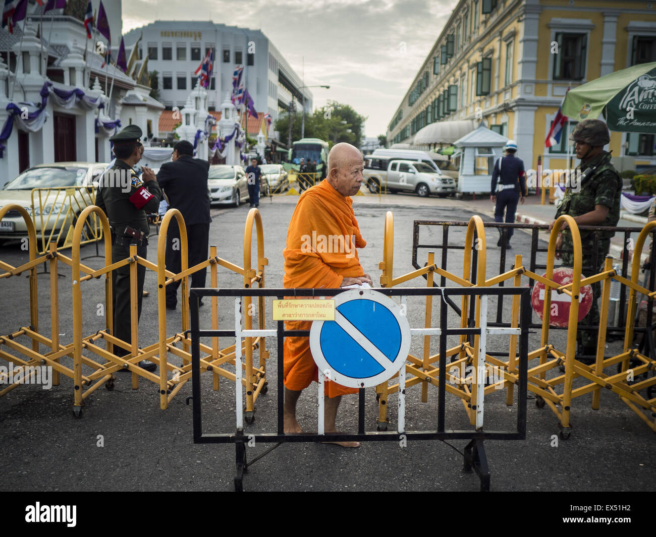 Bangkok, Thailand. 07th July, 2015. A Buddhist monk walks through a military checkpoint in front of the Ministry of Defense in Bangkok before a rally to support students arrested by the military. About 100 people gathered in front of the Ministry of Defense in Bangkok Tuesday to support 14 university students arrested two weeks ago for violating orders against political assembly. They're facing criminal trial in military courts. Credit:  ZUMA Press, Inc./Alamy Live News Stock Photo