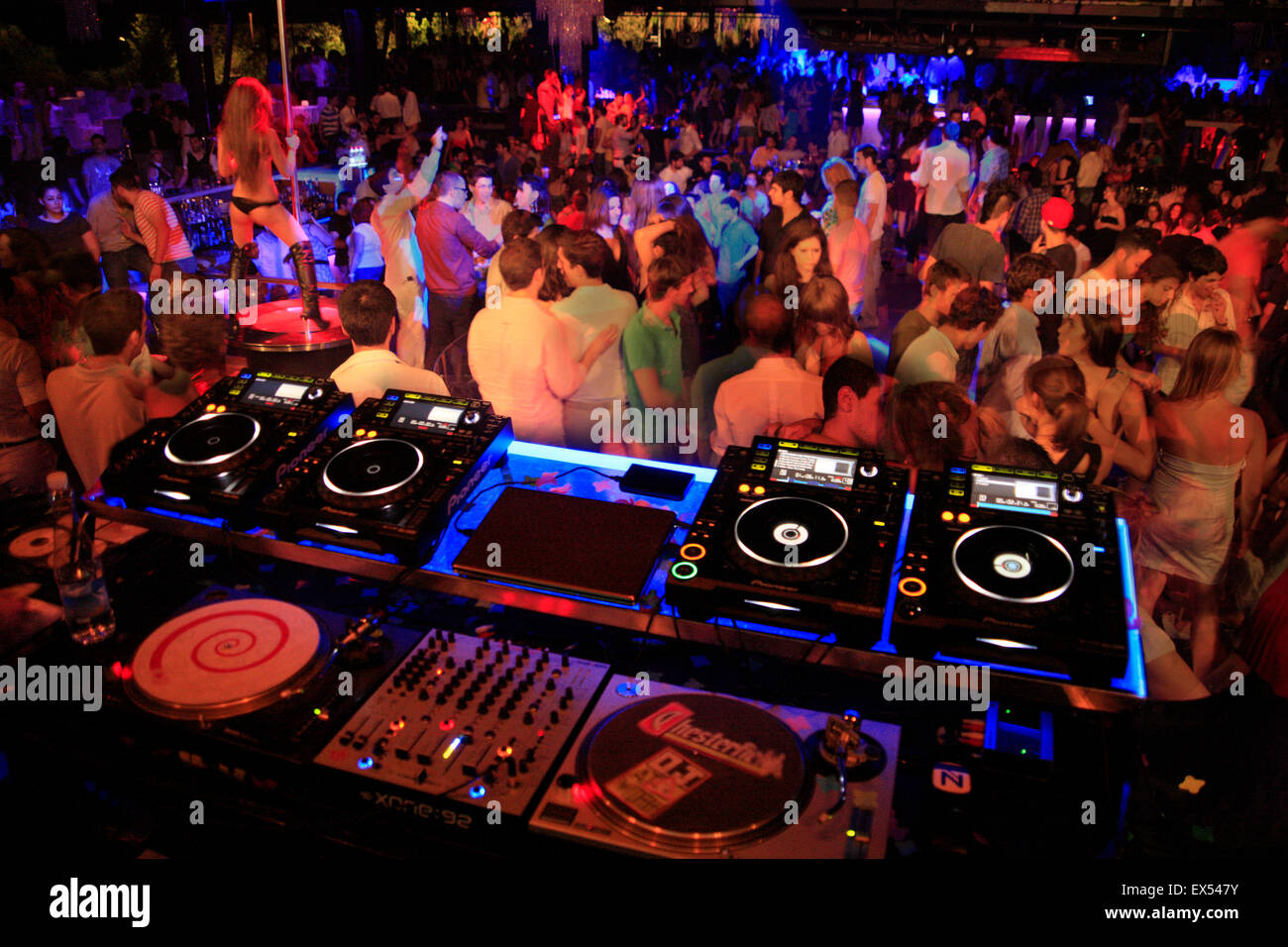 Music / sound mixing decks in foreground and dancing people in a