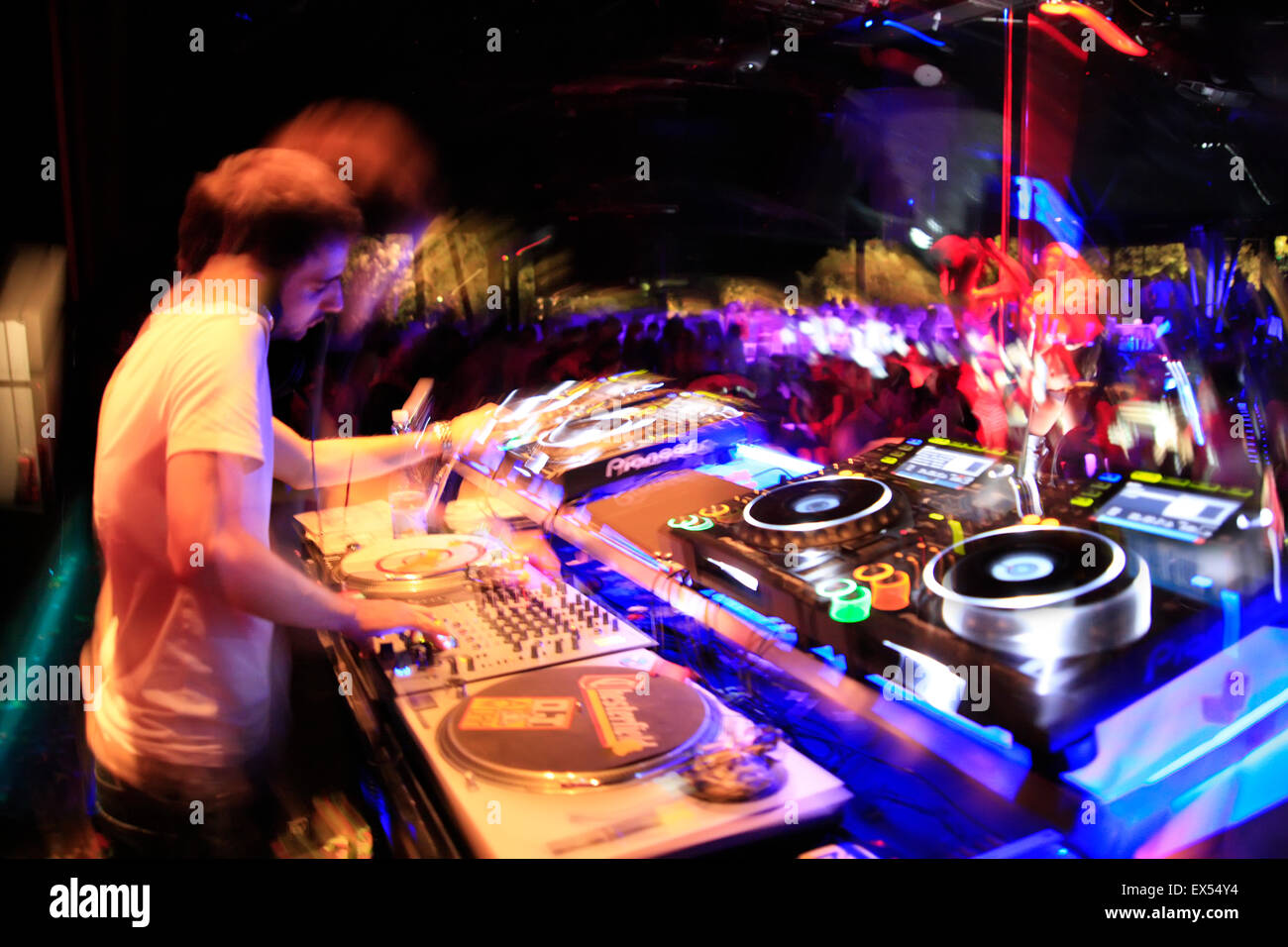 Image full of motion of a DJ on the decks / sound mixing devices and