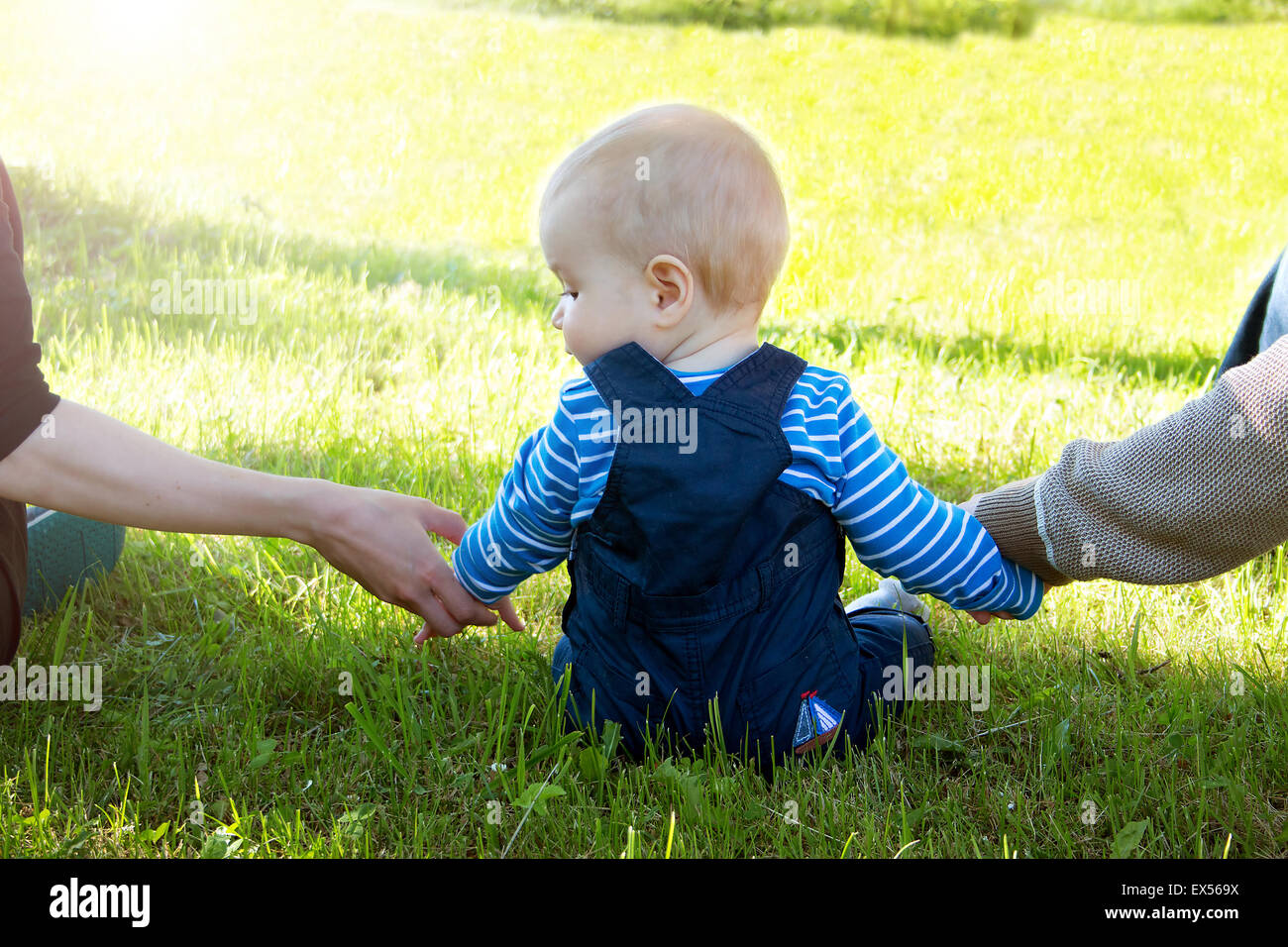 Baby with mother and father holding hands Stock Photo - Alamy
