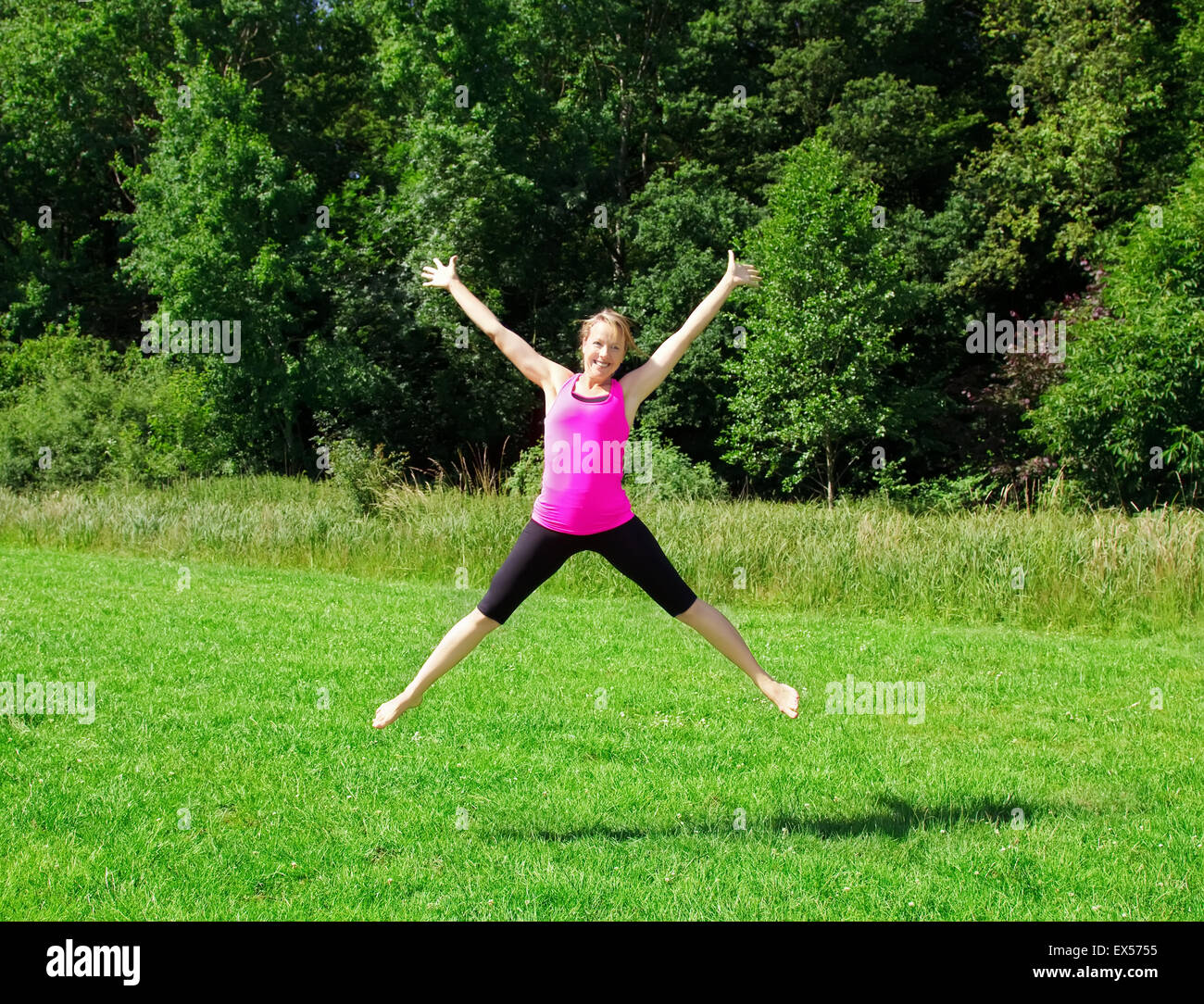 young woman jumping on a meadow Stock Photo