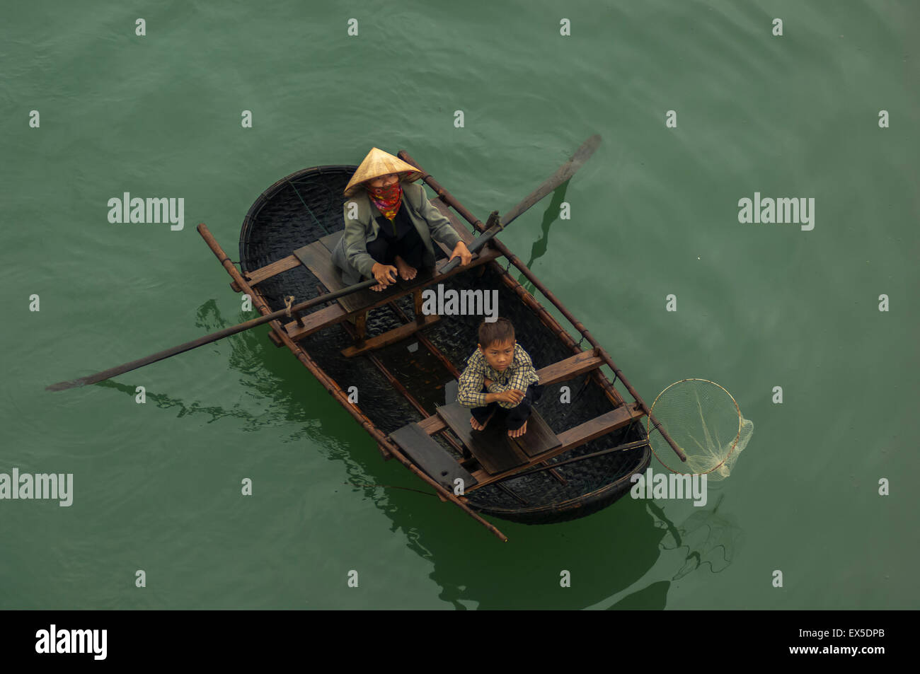 Vietnamese woman and child in rowing boat selling wares Stock Photo