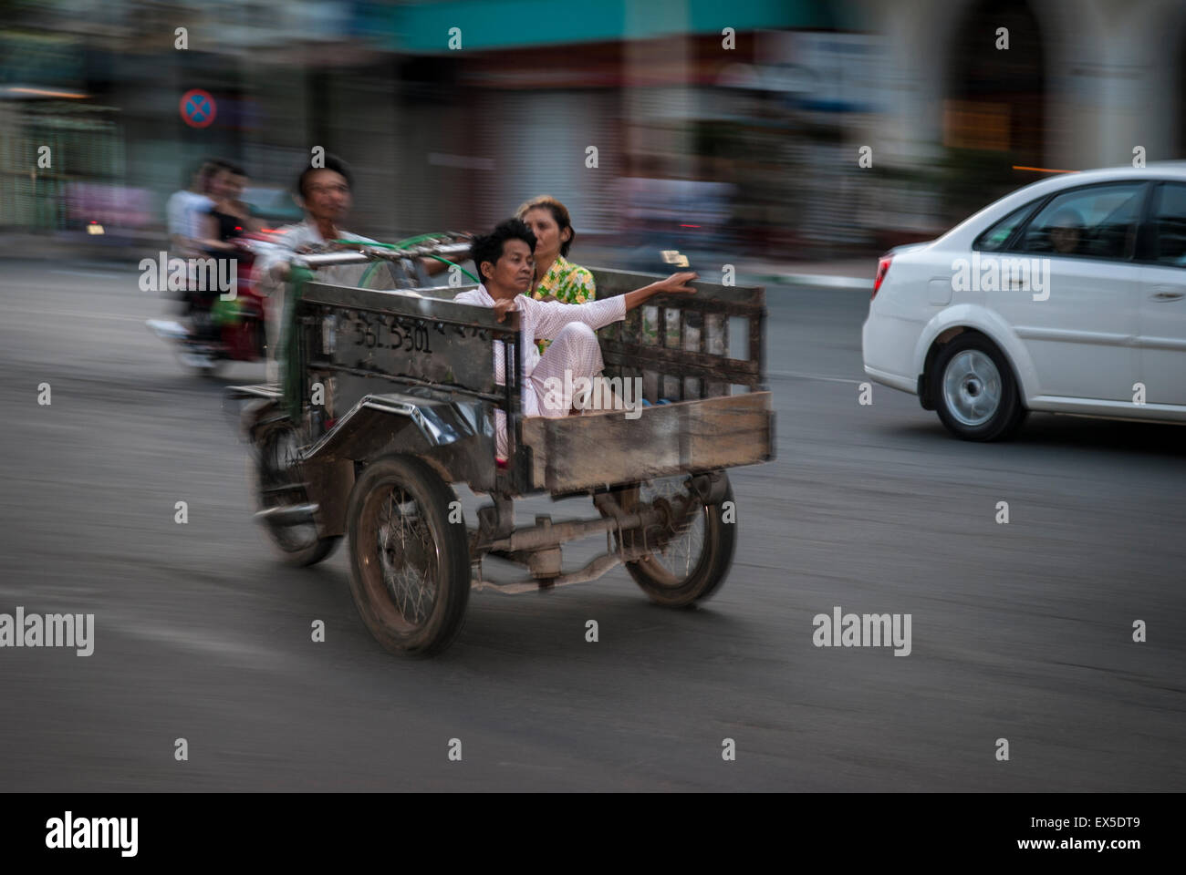 HO CHI MINH CITY/VIETNAM - 18TH MARCH Vietnamese family speed past on a trike in Saigon Stock Photo