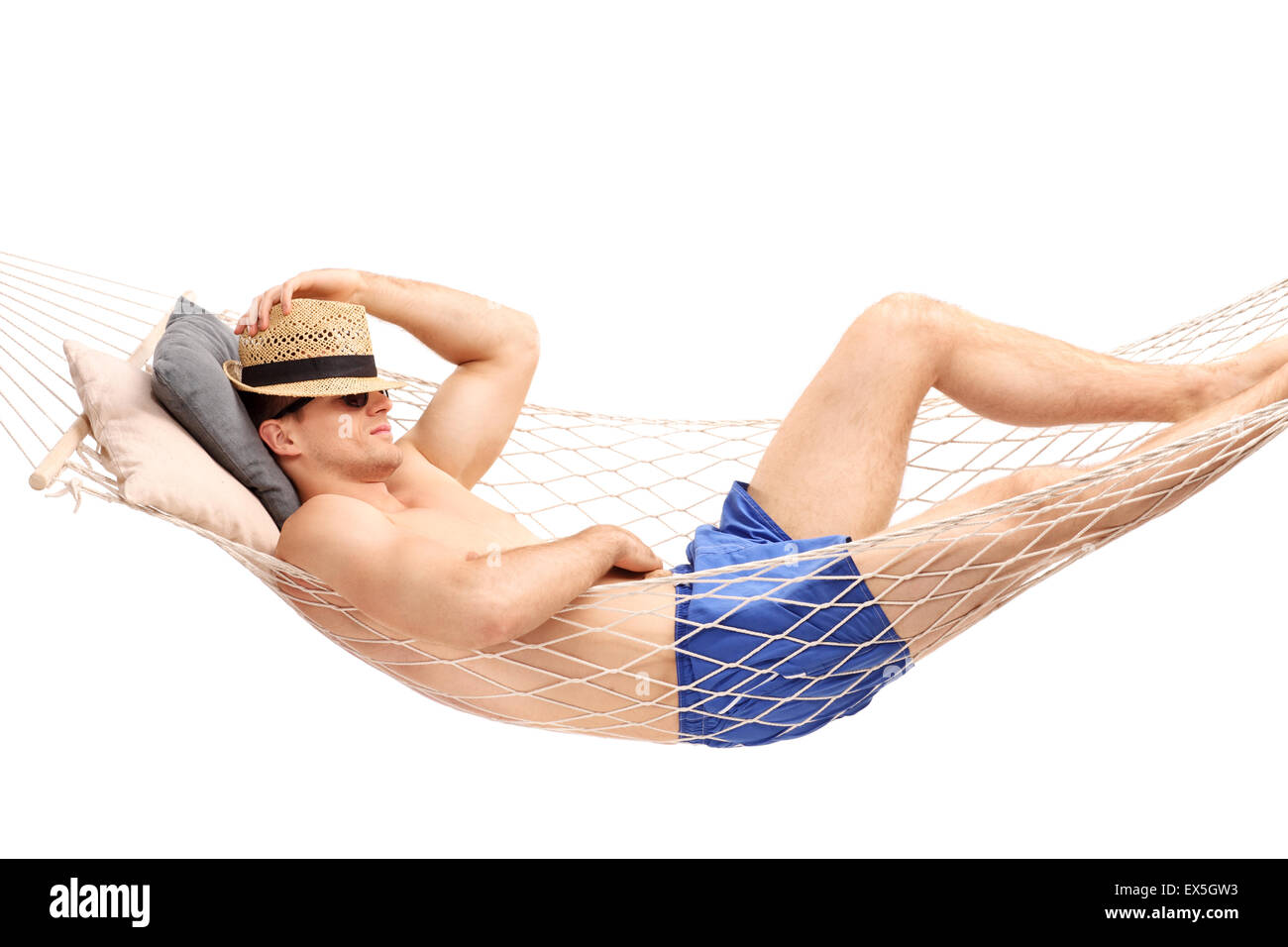 Young guy in blue swim trunks sleeping in a hammock isolated on white background Stock Photo