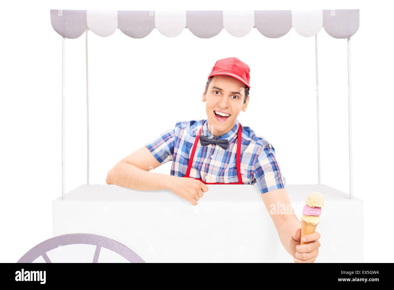 Young male ice cream seller handing an ice cream cone towards the camera isolated on white background Stock Photo