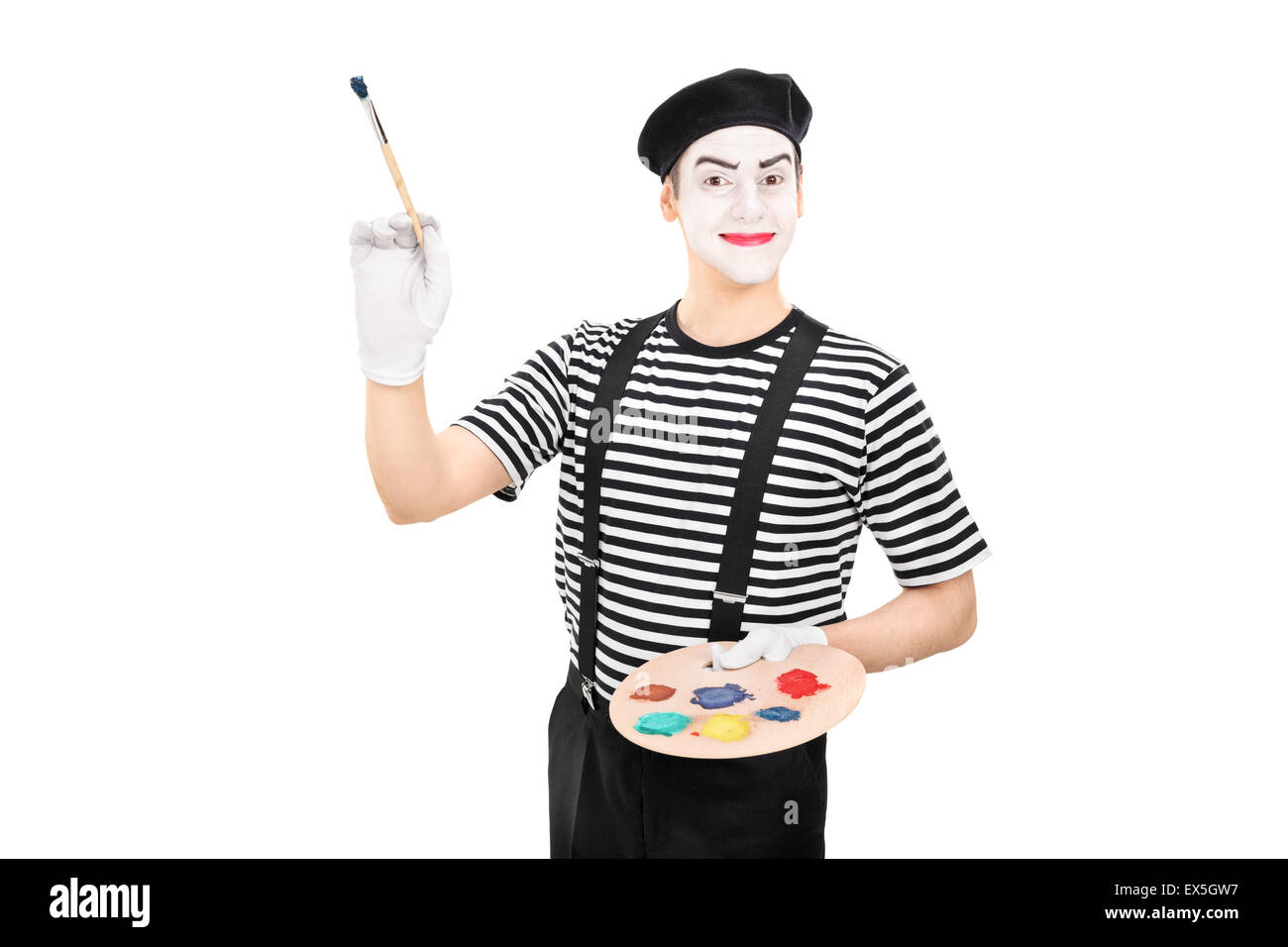 Young male mime artist holding a paintbrush and a color palette isolated on white background Stock Photo