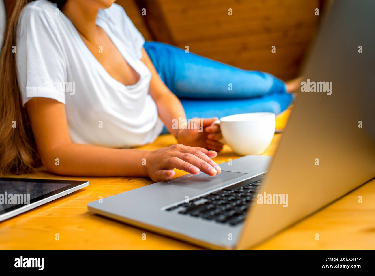 Woman working with laptop on the wooden floor Stock Photo