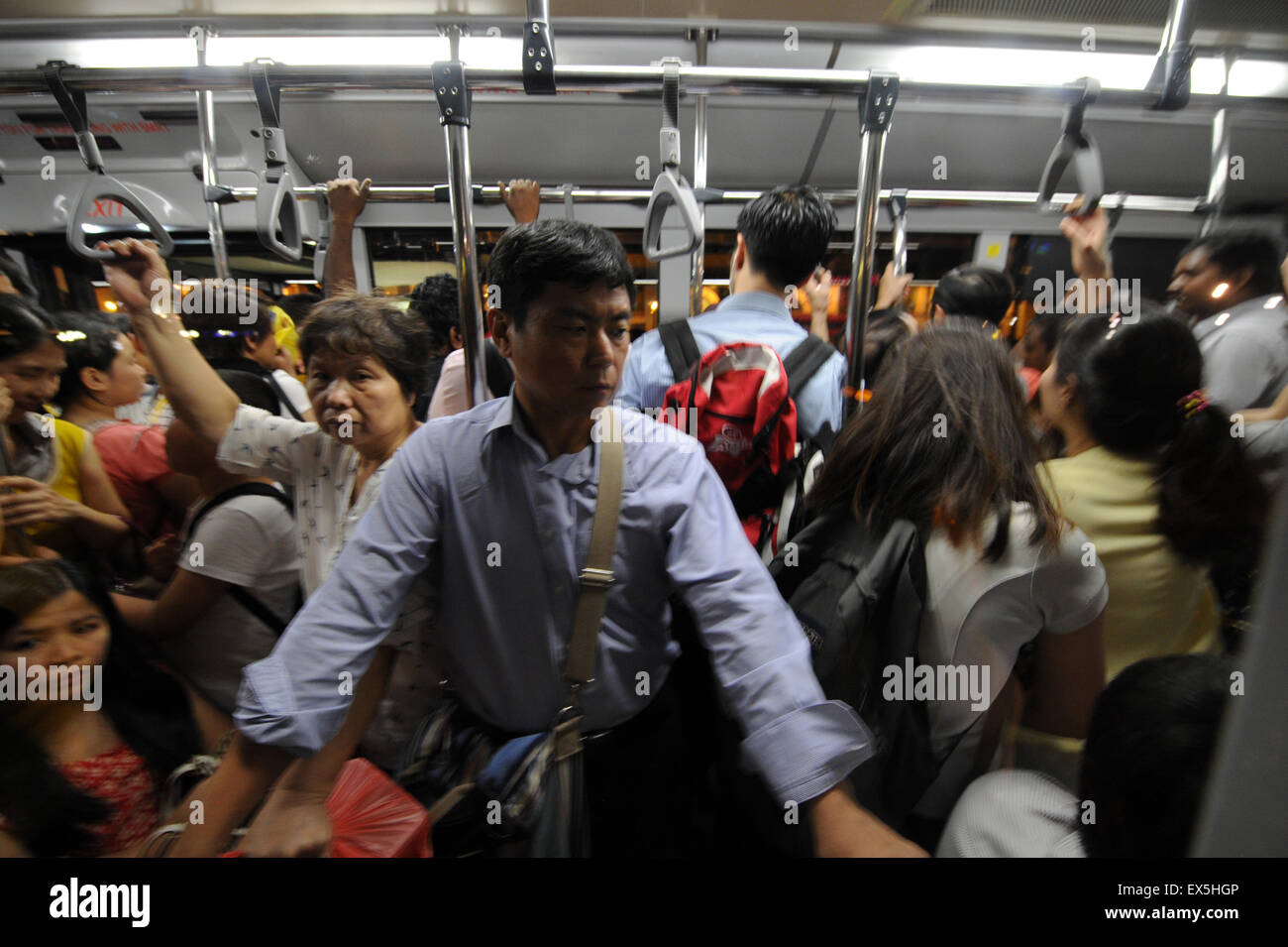Singapore. 7th July, 2015. People squeeze onto a bus near Singapore's Dhoby Ghaut MRT Station on July 7, 2015. Train services on Singapore's North-South and East-West MRT Lines were disrupted at evening peak hours due to electrical malfunction on Tuesday, the second time after the East-West MRT Line malfunction in March. © Then Chih Wey/Xinhua/Alamy Live News Stock Photo
