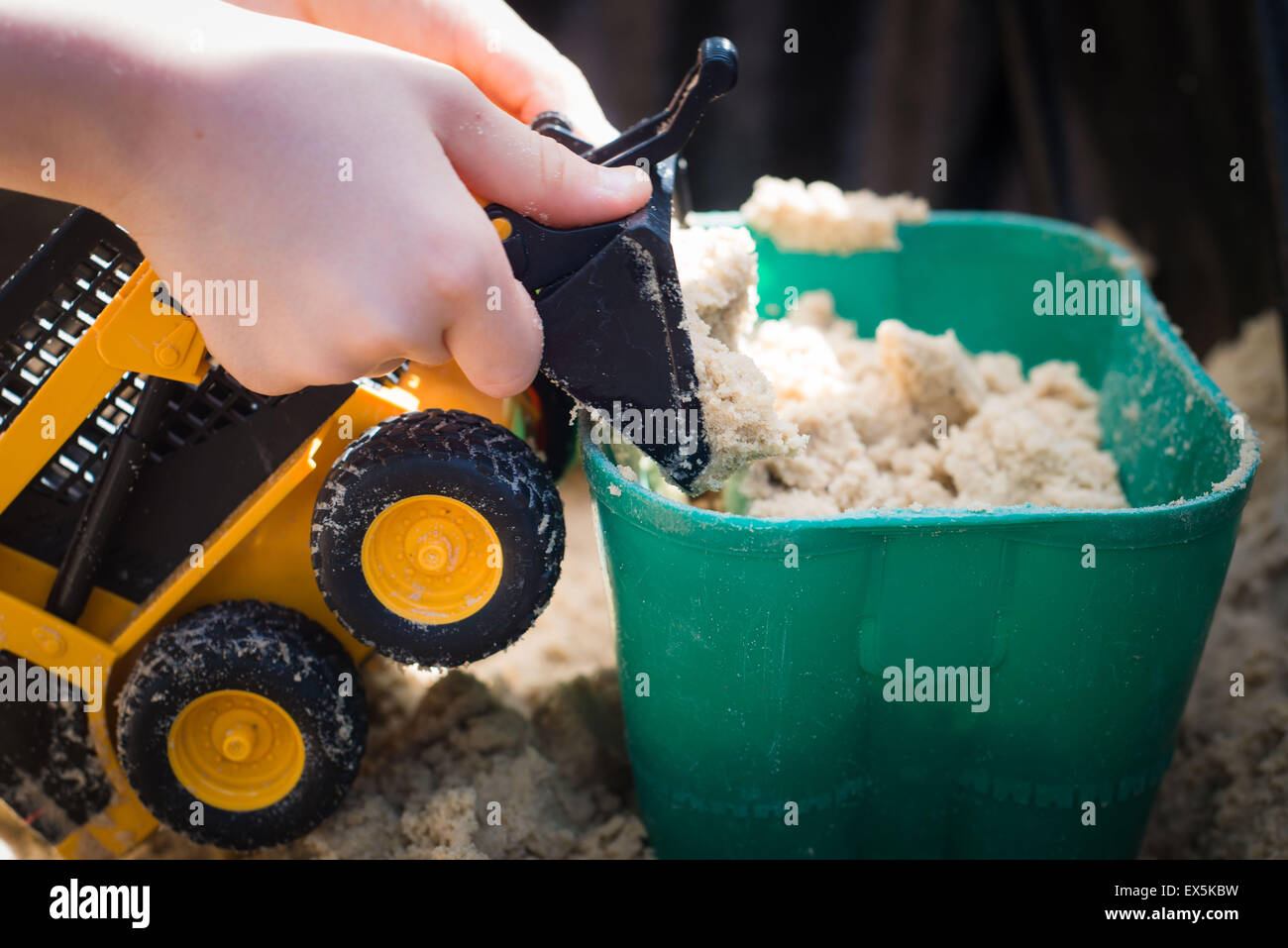 child playing with digger truck in sand pit Stock Photo