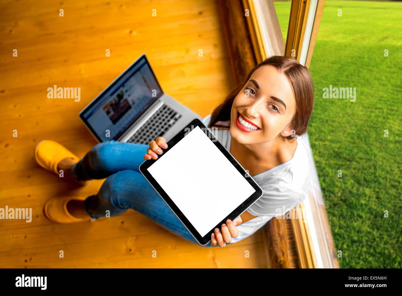 Woman showing digital tablet in the wooden house Stock Photo