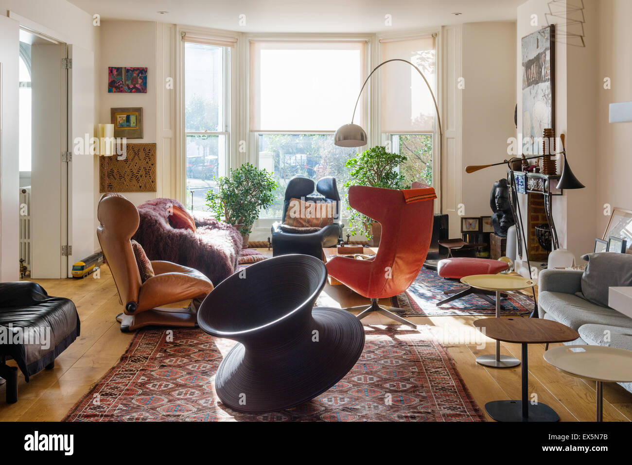 Round chair by thomas Heatherwick in sitting room with pale Conran sofa, moroccan rugs and Arc lamp by Archille Castiglione Stock Photo