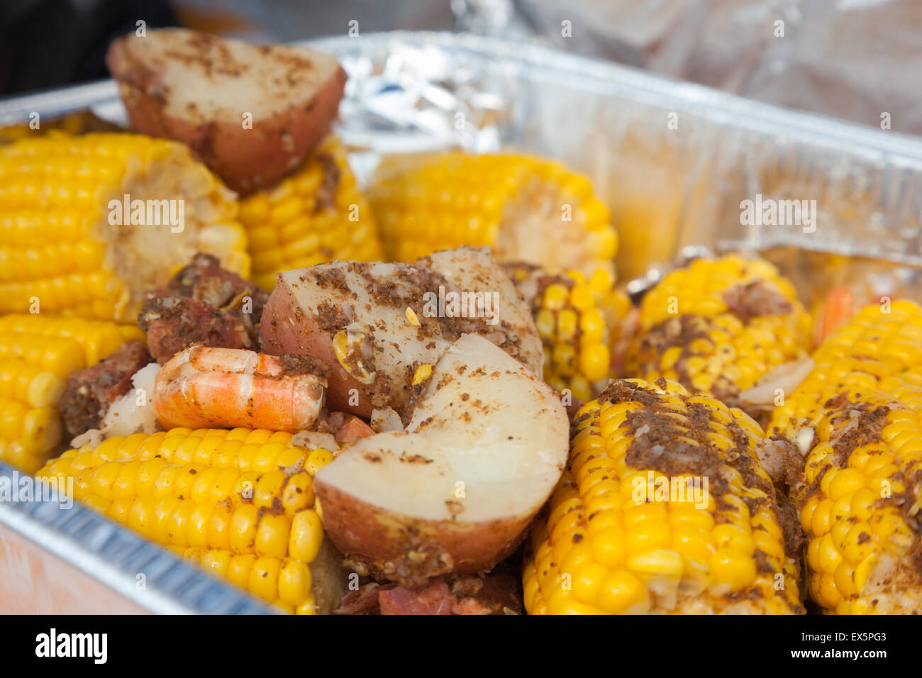 A traditional low country boil with red potatoes, corn on the cob, and shrimp. Stock Photo