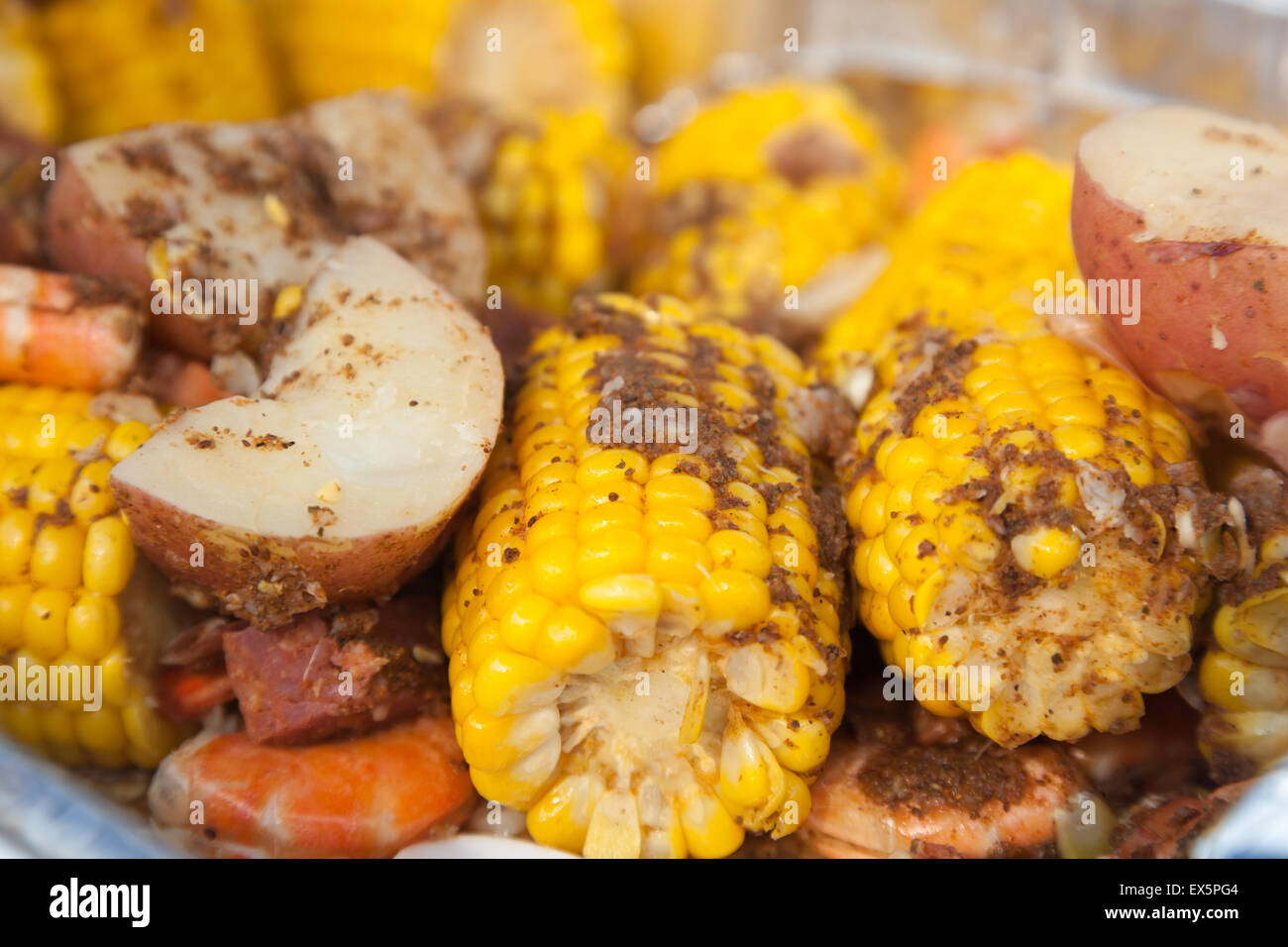 A traditional low country boil with red potatoes, corn on the cob, and shrimp. Stock Photo