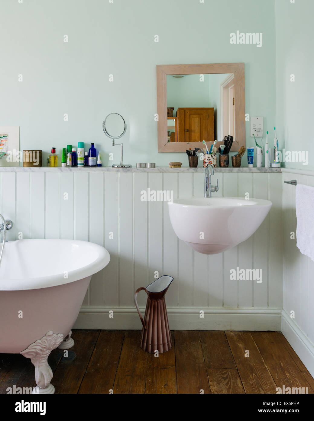 Villeroy and Boche sink and taps in light blue bathroom with freestanding roll-top bath Stock Photo