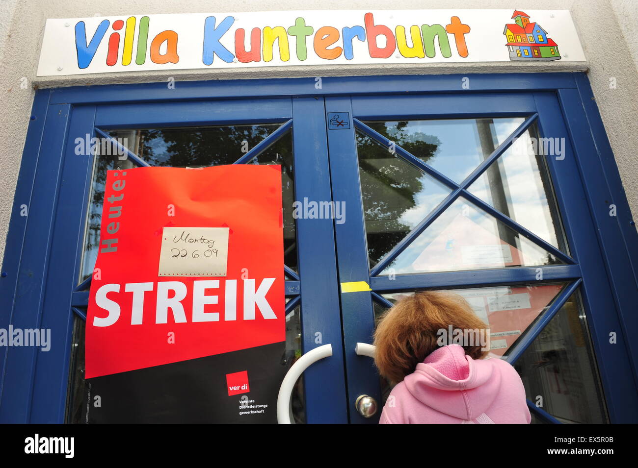 Worms, Germany - June 22, 2009 - Girl waiting in front of closed kindergarten Stock Photo
