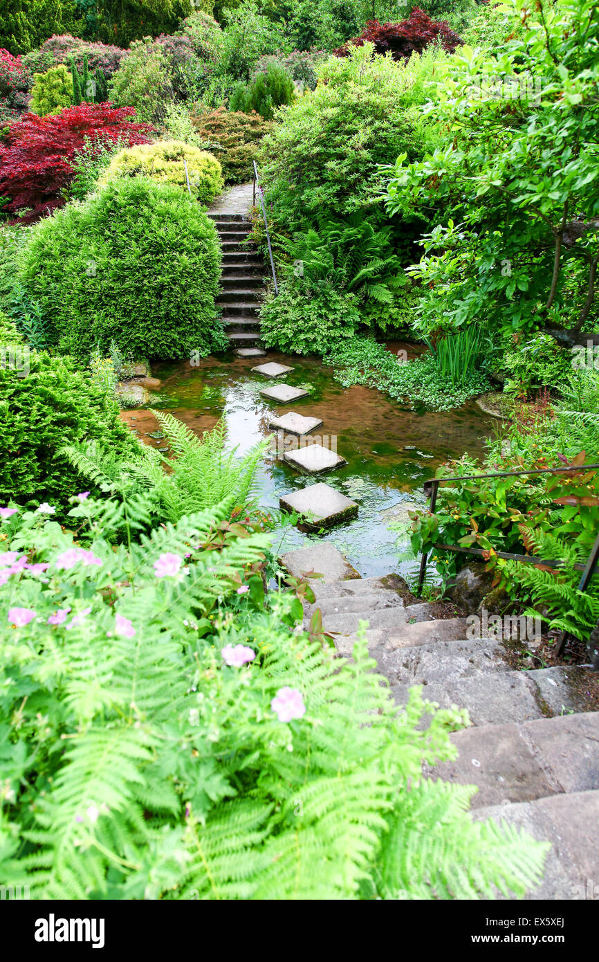 Steps and stepping stones leading across a stream at Alton Towers Estate Theme Park Gardens Staffordshire England UK Stock Photo