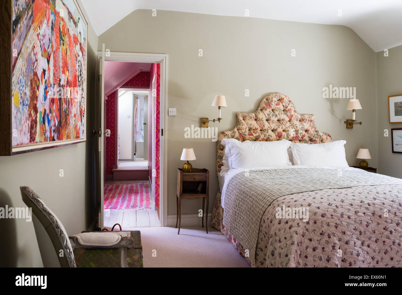Mounted fabric print on wall of cottage bedroom with quilted throw and Bennison's Shangri-la fabric curtains Stock Photo