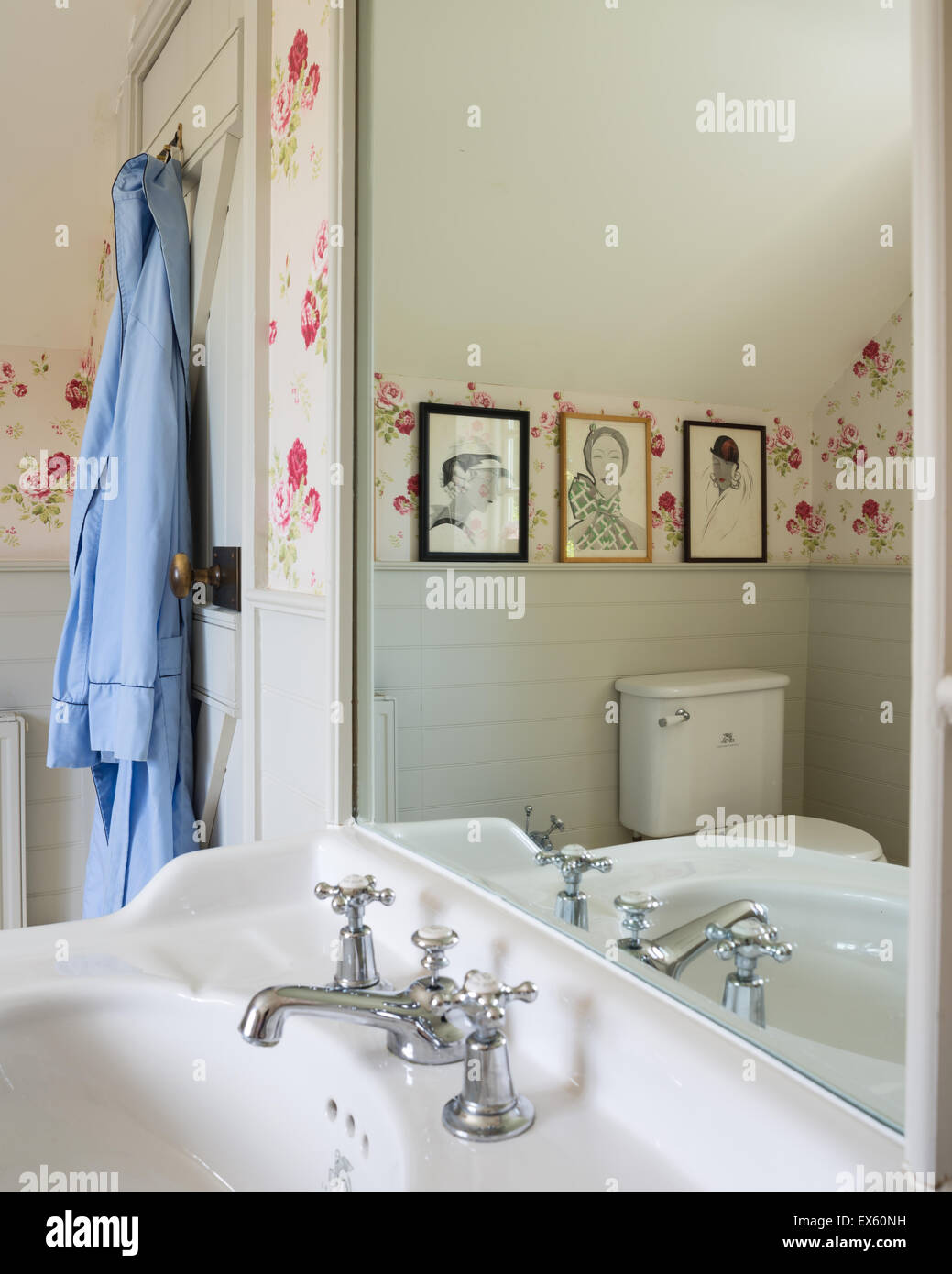Cath Kidston wallpaper in simple cottage bathroom with framed American fashion drawings Stock Photo