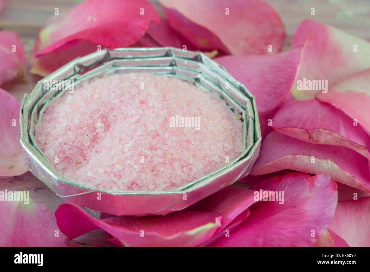 Pink aromatic bath salt on a table decorated with rose petals Stock Photo