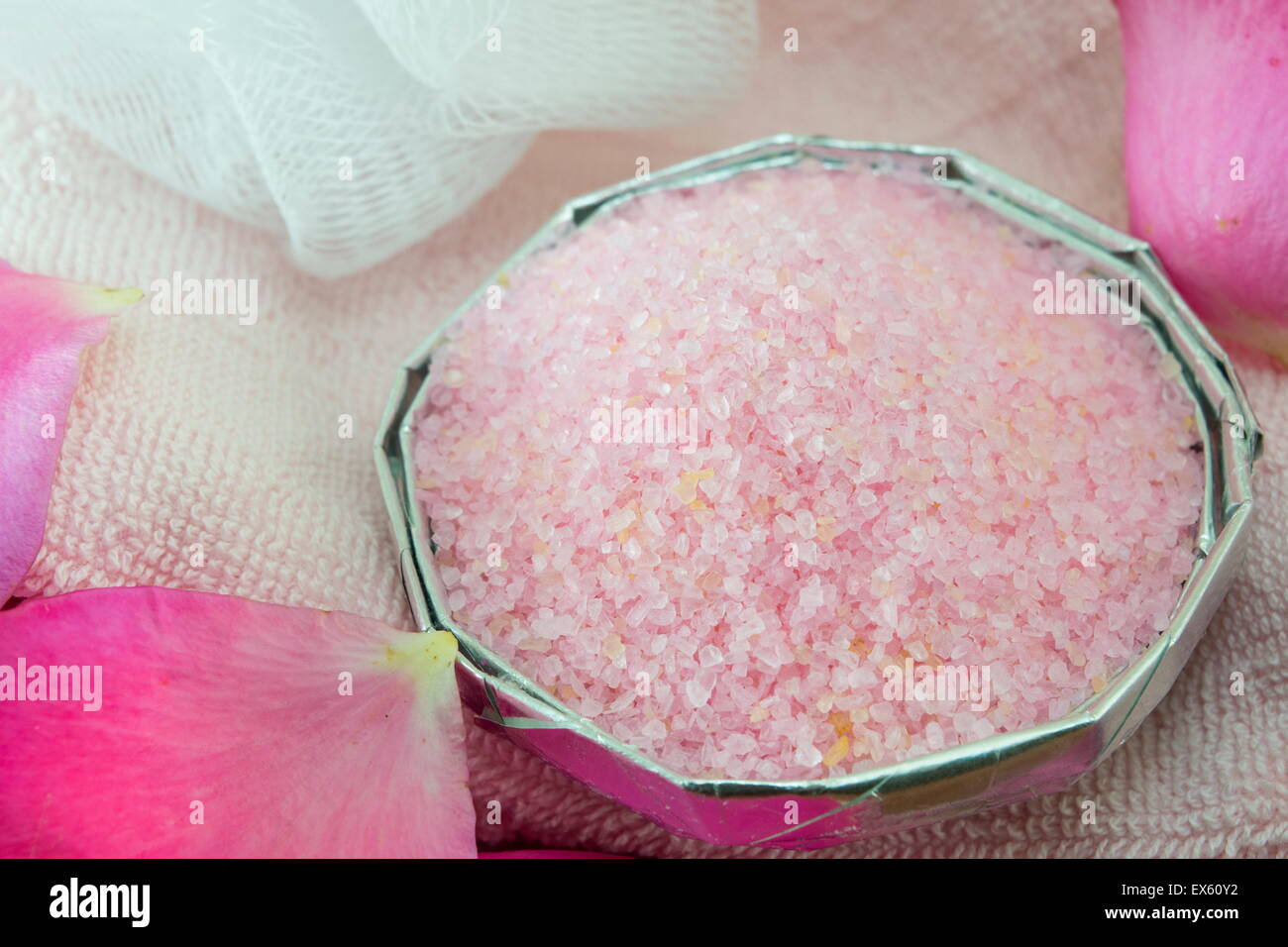 Pink aromatic bath salt on a table decorated with rose petals Stock Photo