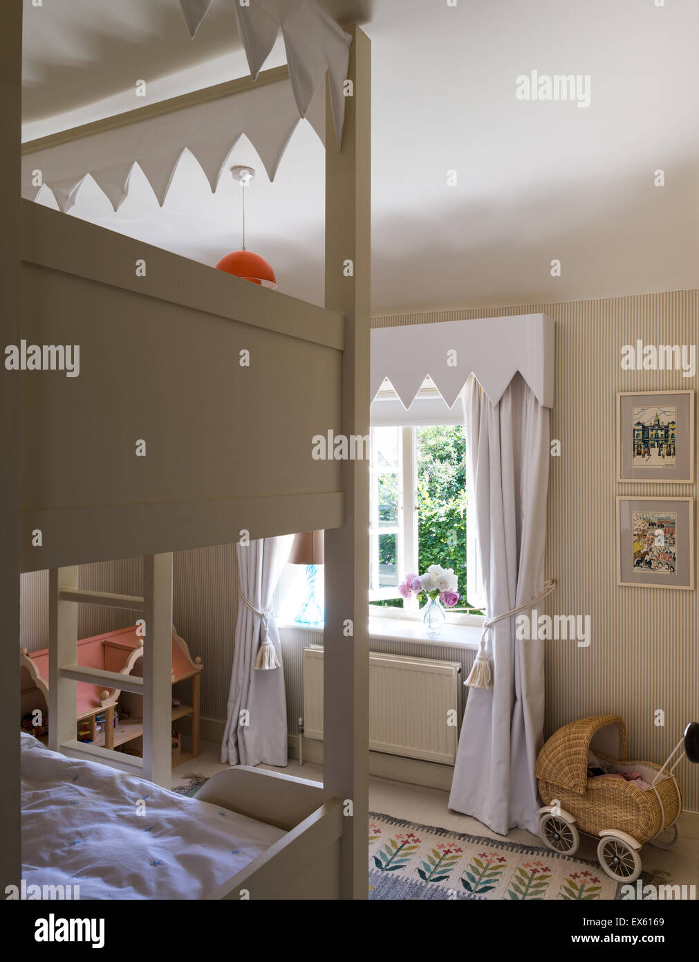 Osborn and Little striped wallpaper in kids bedroom with bunk beds and Polish folk rug Stock Photo