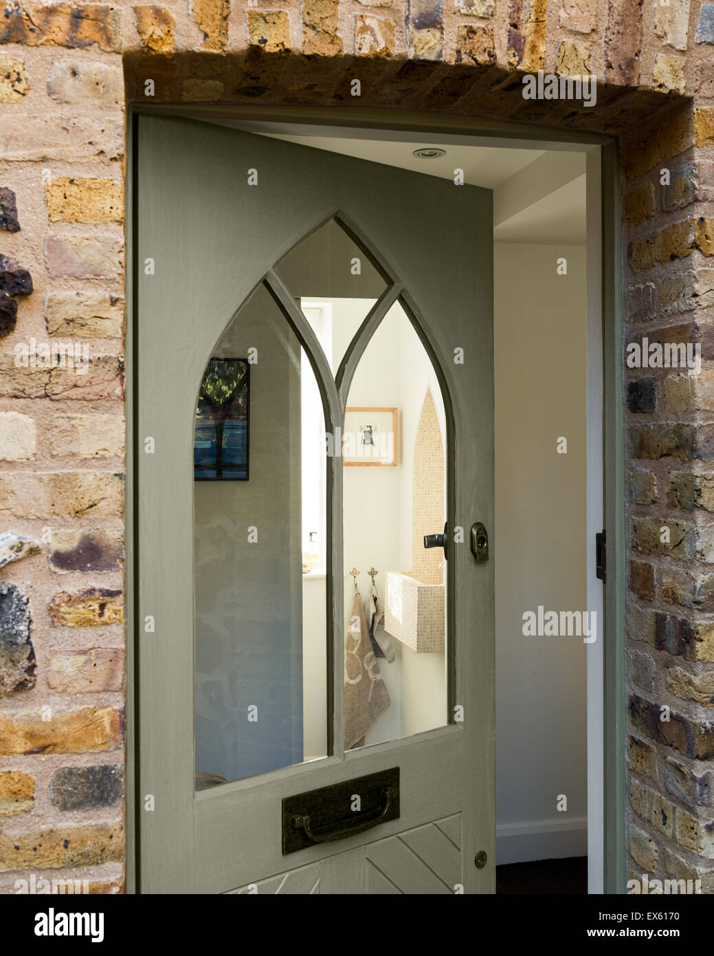 front door with gothic style front door and brick quoin and flint surround Stock Photo