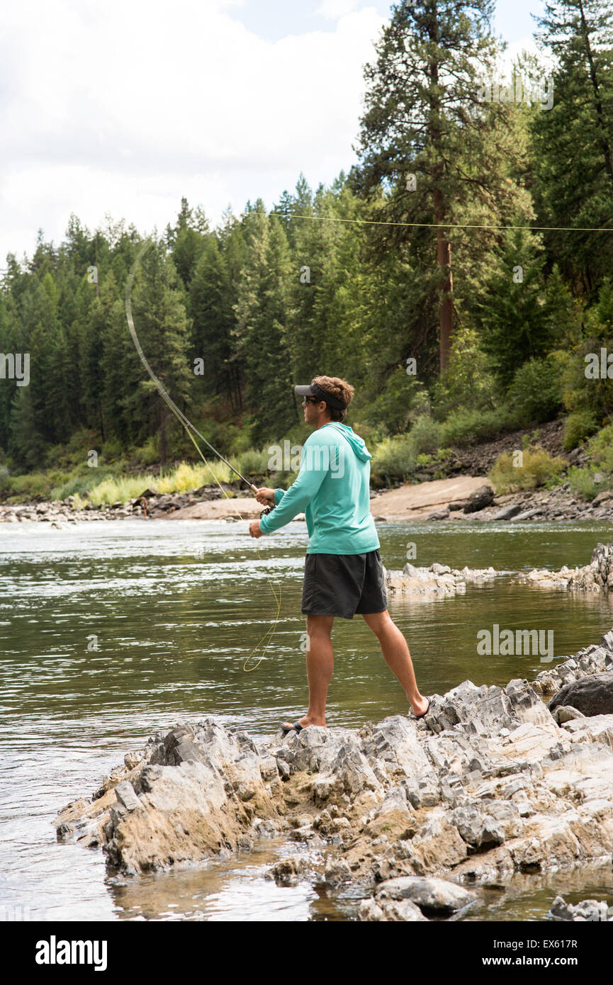 Young flyfisherman casting his rod into a Montana river Stock Photo