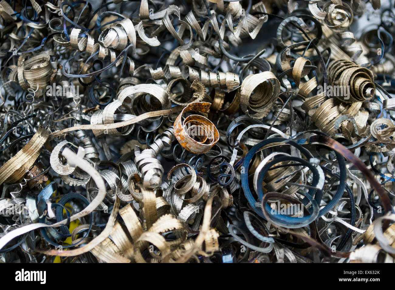 Curled metallic cuts or swarf from metal machining tool, background Stock Photo