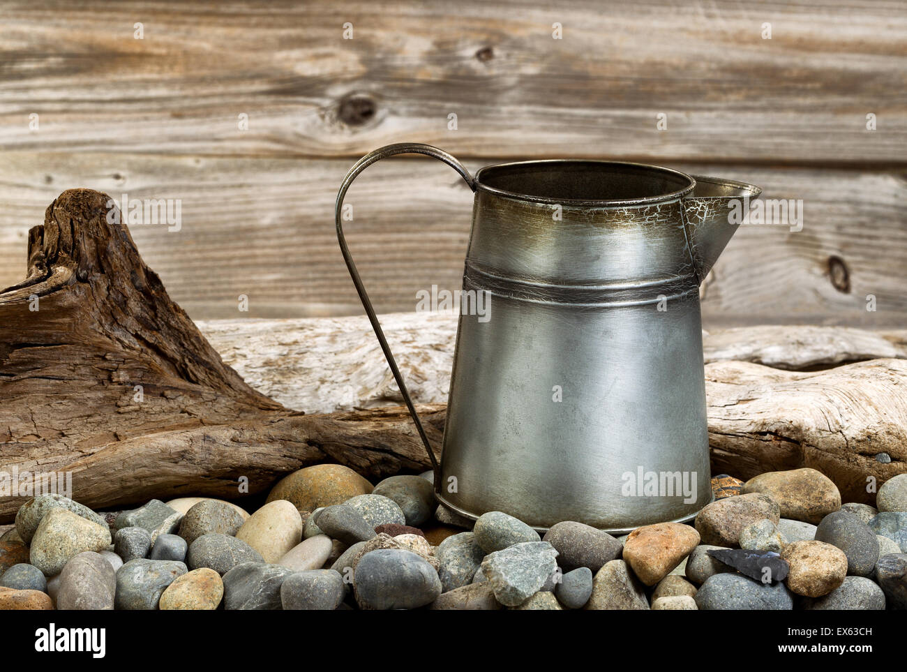 Traditional metal coffee pot on fire pit made of stones and drift wood