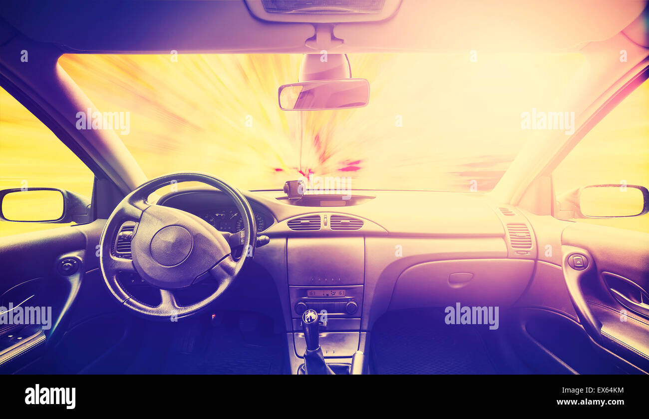 Vintage retro toned picture of a car interior at sunset. Stock Photo