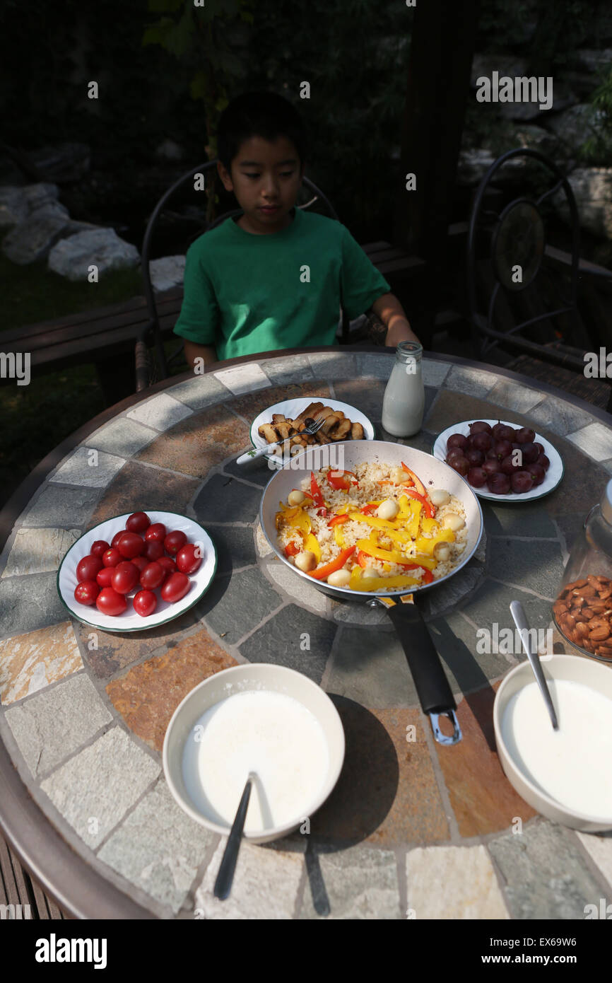 Boy having breakfast in back yard Stock Photo