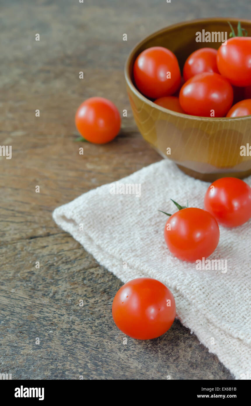 Red cherry tomatoes on a textured wooden background Stock Photo - Alamy
