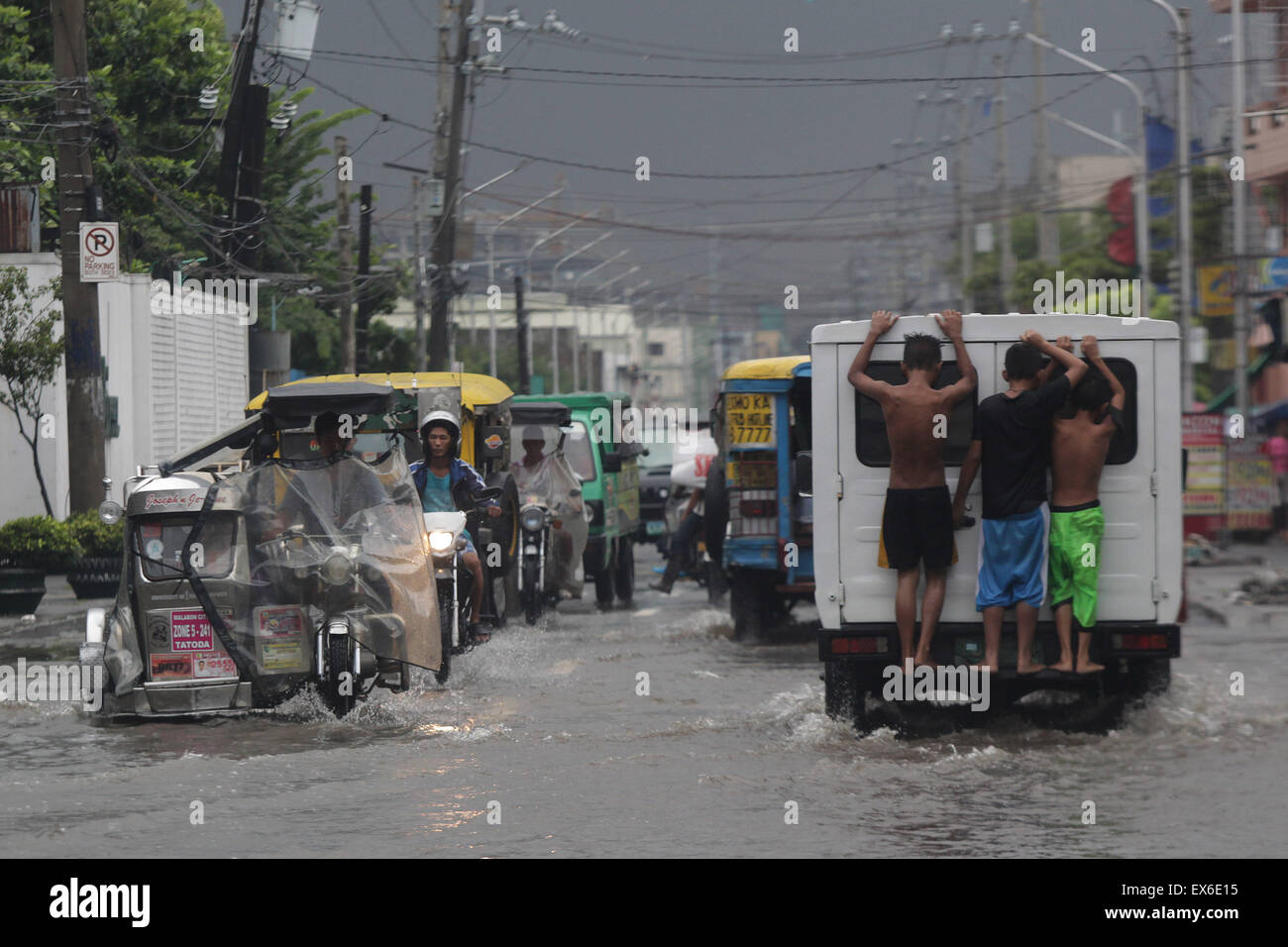 Malabon City, Philippines. 8th July, 2015. Residents wade through a flooded street in Malabon City, the Philippines, July 8, 2015. Typhoon Chan-hom (local name Falcon) with maximum sustained winds of 130 kph near the center and gustiness of up to 160 kph brought heavy rain, strong winds, lightning and floods in northern Philippines, causing school and office suspensions, and cancellations in air and sea travel. Credit:  Rouelle Umali/Xinhua/Alamy Live News Stock Photo