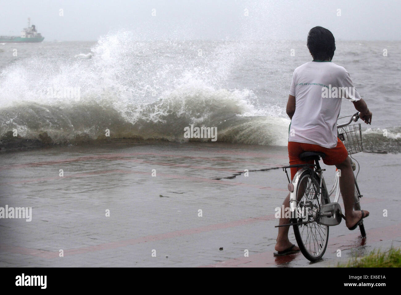 Navotas City, Philippines. 8th July, 2015. A man looks at crashing waves in Navotas City, the Philippines, July 8, 2015. Typhoon Chan-hom (local name Falcon) with maximum sustained winds of 130 kph near the center and gustiness of up to 160 kph brought heavy rain, strong winds, lightning and floods in northern Philippines, causing school and office suspensions, and cancellations in air and sea travel. Credit:  Rouelle Umali/Xinhua/Alamy Live News Stock Photo