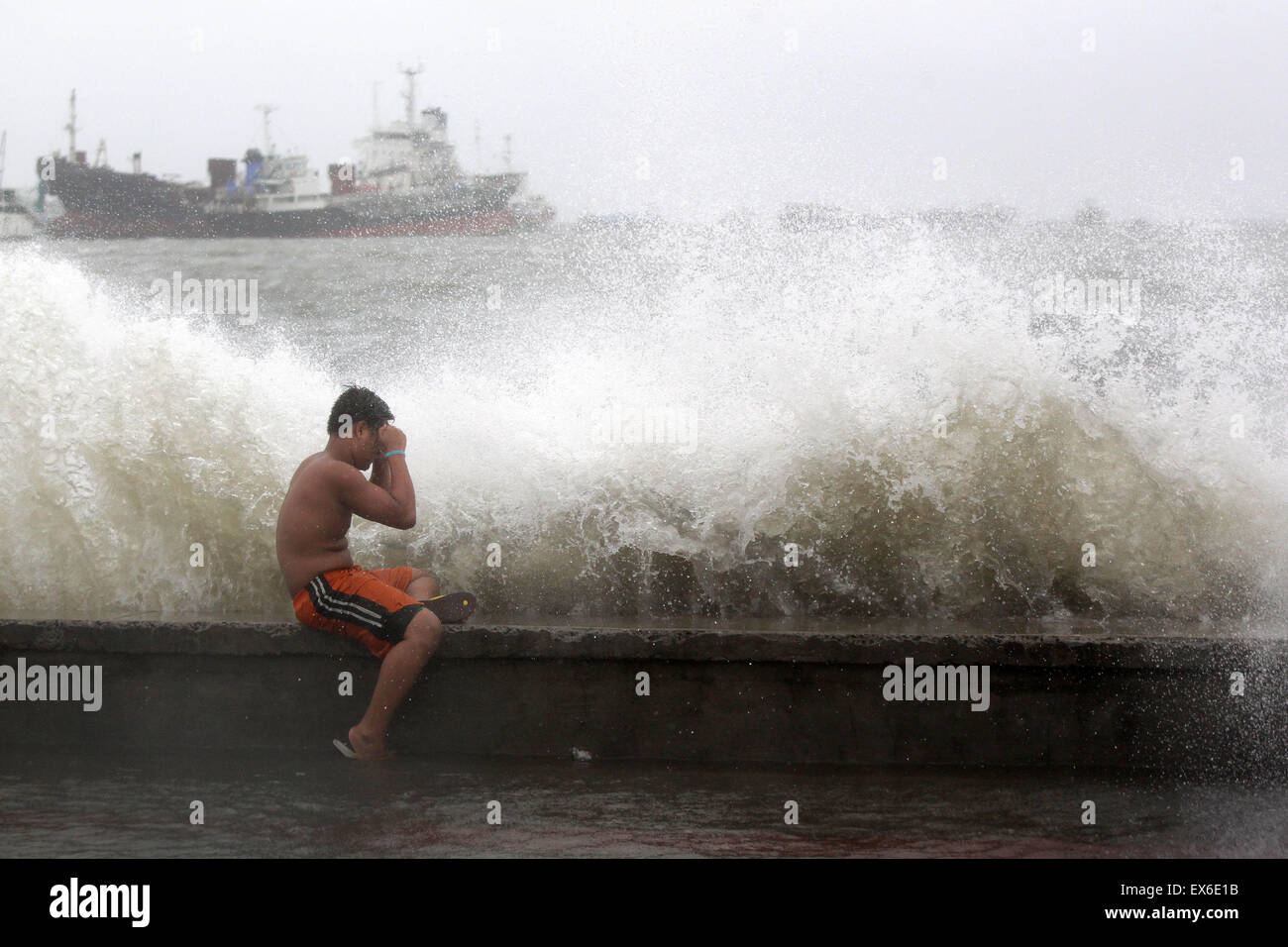 Navotas City, Philippines. 8th July, 2015. Waves hit a resident in Navotas City, the Philippines, July 8, 2015. Typhoon Chan-hom (local name Falcon) with maximum sustained winds of 130 kph near the center and gustiness of up to 160 kph brought heavy rain, strong winds, lightning and floods in northern Philippines, causing school and office suspensions, and cancellations in air and sea travel. Credit:  Rouelle Umali/Xinhua/Alamy Live News Stock Photo