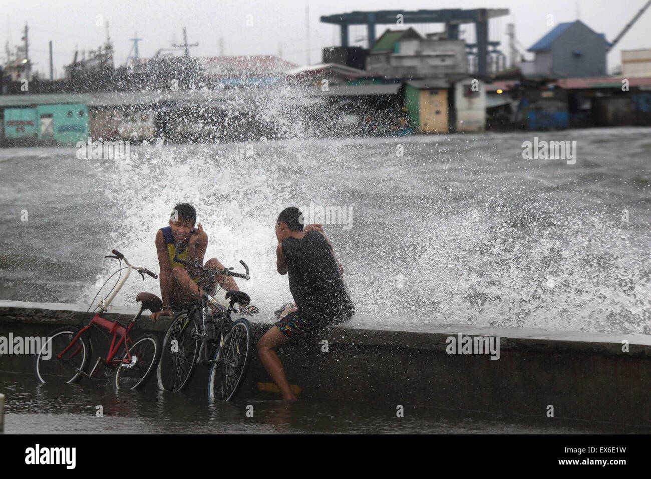 Navotas City, Philippines. 8th July, 2015. Waves hit residents in Navotas City, the Philippines, July 8, 2015. Typhoon Chan-hom (local name Falcon) with maximum sustained winds of 130 kph near the center and gustiness of up to 160 kph brought heavy rain, strong winds, lightning and floods in northern Philippines, causing school and office suspensions, and cancellations in air and sea travel. Credit:  Rouelle Umali/Xinhua/Alamy Live News Stock Photo