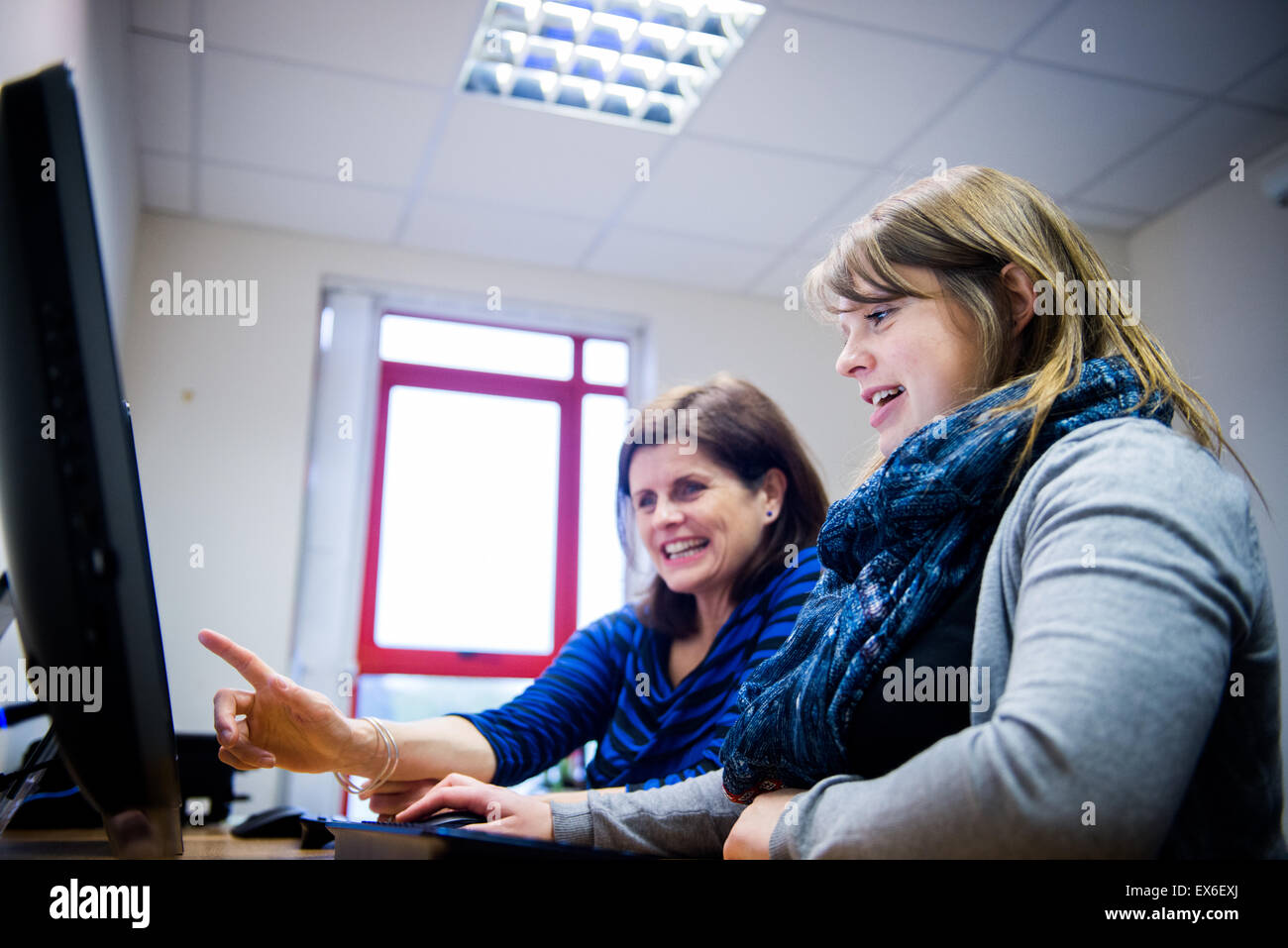 Young woman being trained on how to use software by manager Stock Photo