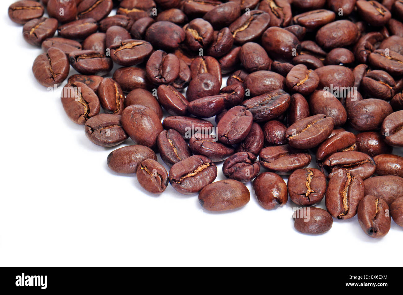 a pile of roasted coffee beans on a white background Stock Photo - Alamy